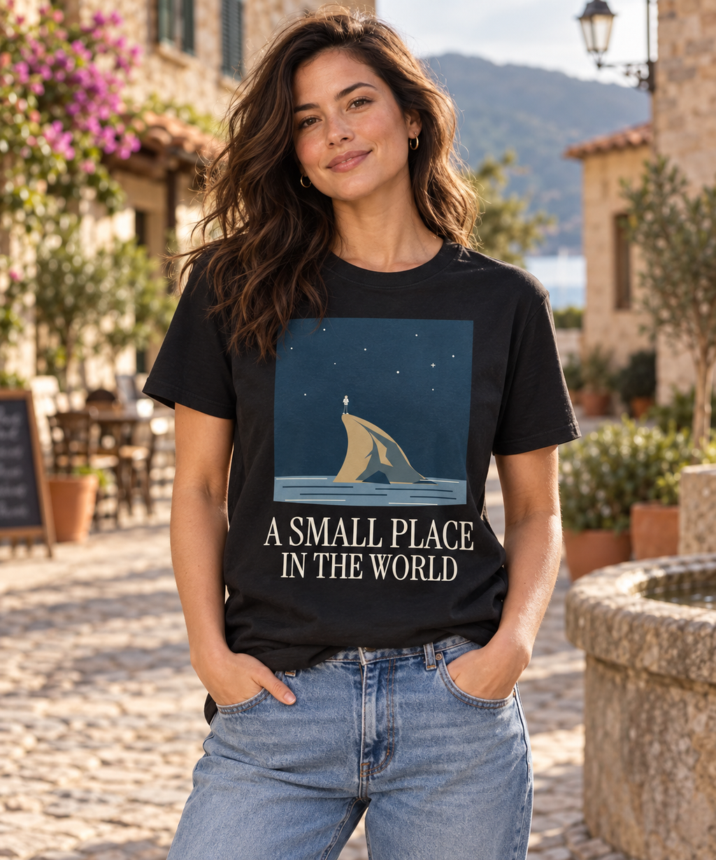 A Small Place in the World — Male model wearing a dark T-shirt with light front artwork. Daily Elsewhere.