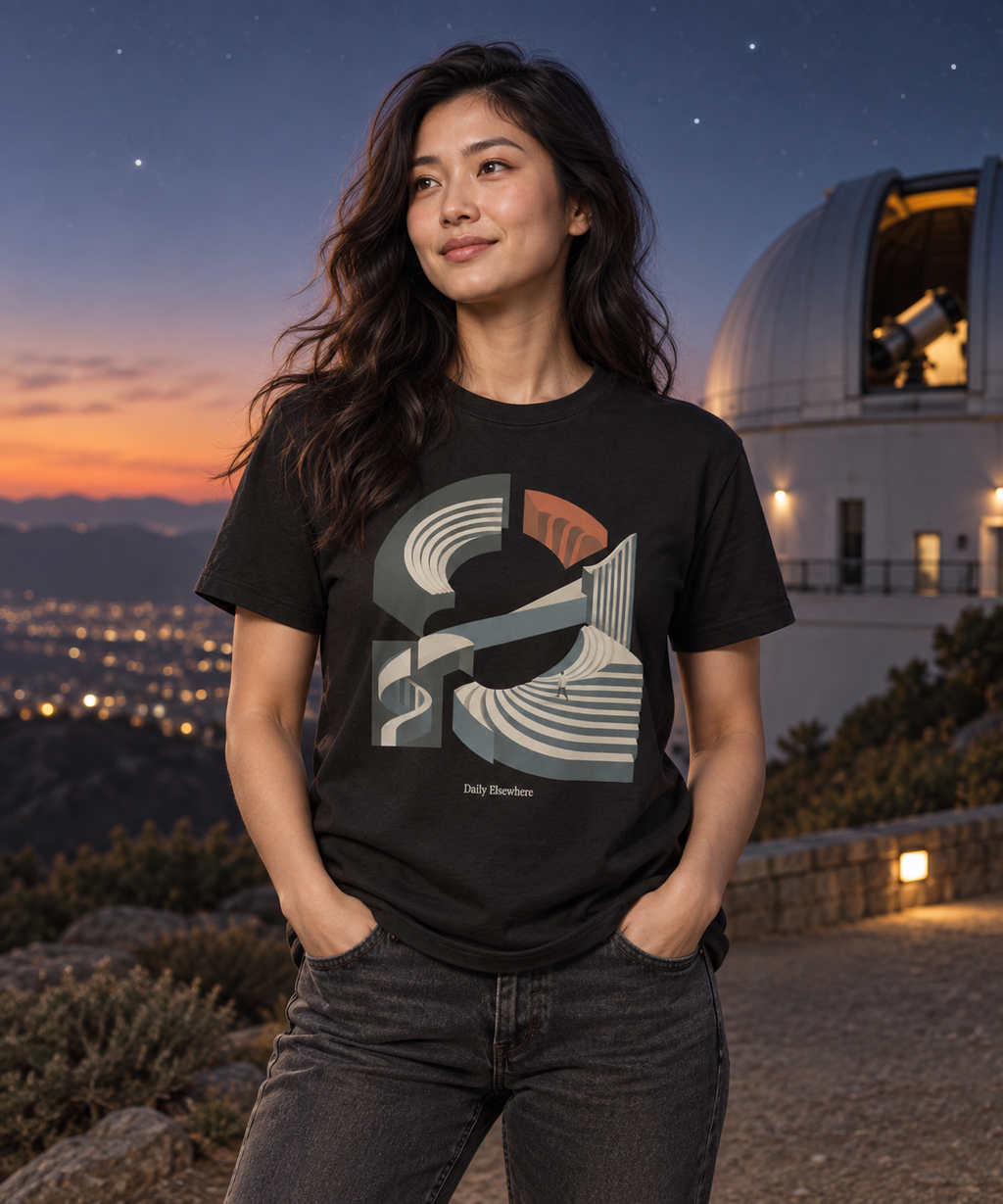 Unfixed Orbit — Female model wearing a dark T-shirt with light front artwork. Daily Elsewhere.