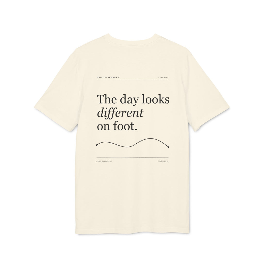 Back of a Natural Raw organic-cotton T-shirt with “The day looks different on foot” graphic.