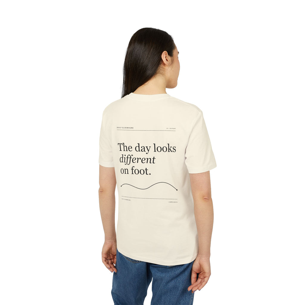 Model wearing the Natural Raw Daily Elsewhere T-shirt, showing the back graphic.